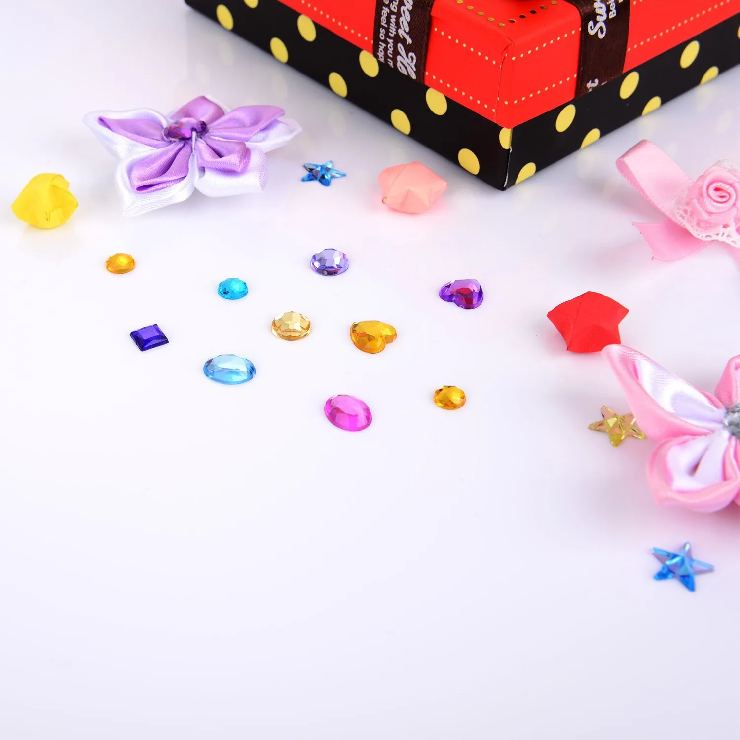 Gems, bows and rolls of ribbon laid out for a seasonal table