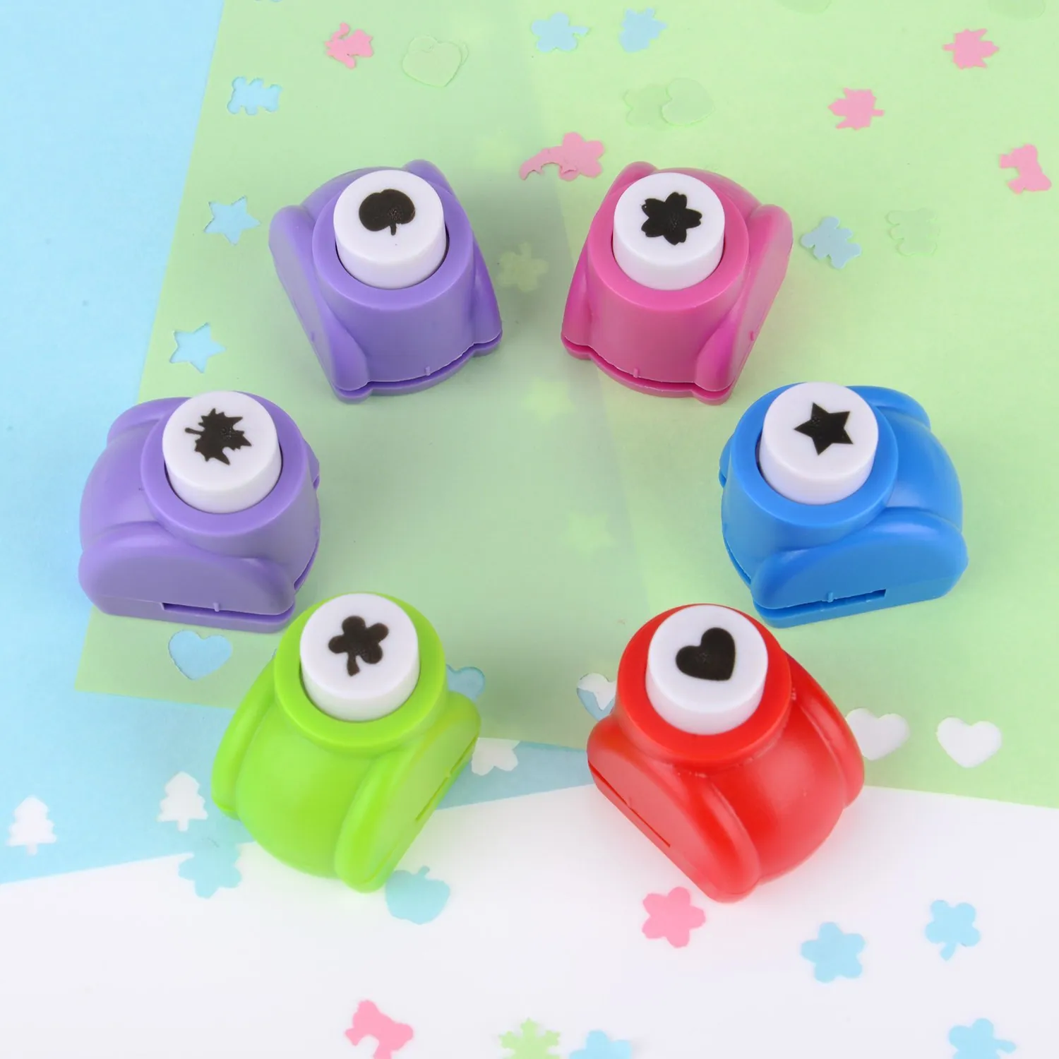Craft shape punches and punched paper shapes on a pastel bench